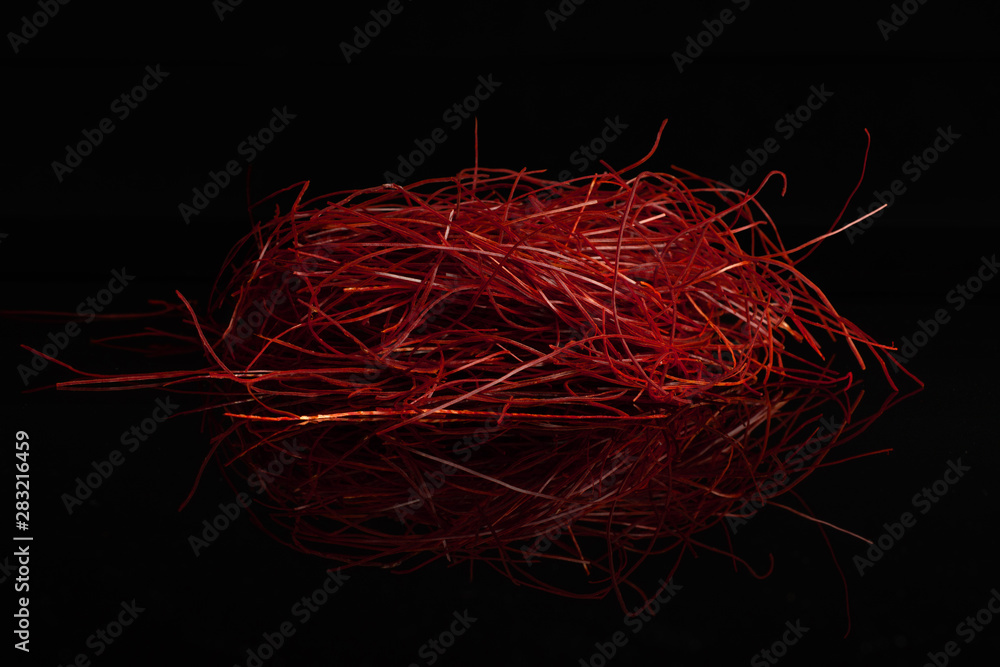 Fototapeta premium Lot of whole red chili pepper threads isolated on black glass