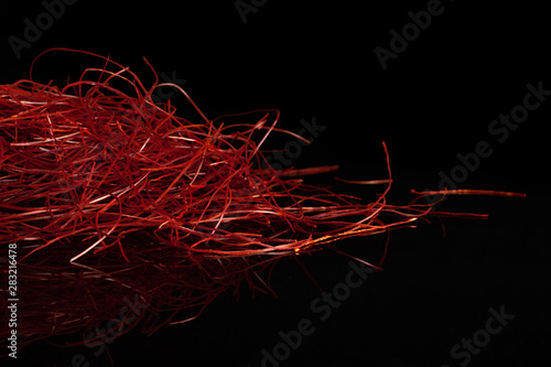 Lot of whole red chili pepper threads heap isolated on black glass