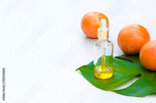 Bottles with cosmetic natural  products  and vitamin C serum on green leav,  on white background. Beauty salon treatments concept. soft focus; copy space; mock up, isolated.