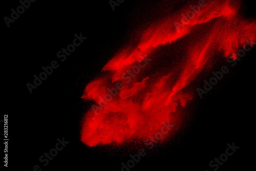 Red powder explosion on black background. Freeze motion of Red dust particles splash.