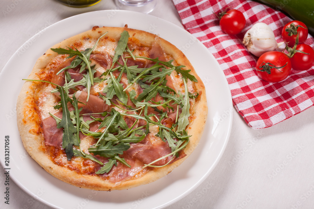 Close up of Pizza with prosciutto (parma ham) and arugula (salad rocket). Vegetables Close up of Pizza with prosciutto (parma ham) and arugula (salad rocket). Vegetables