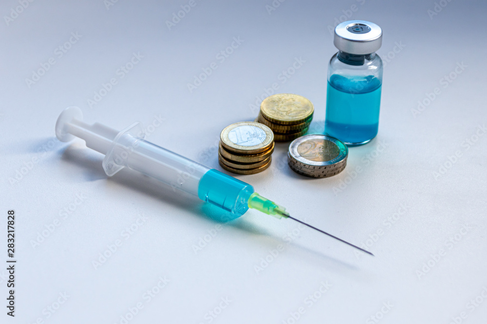 Spritze und Ampulle mit neu entwickeltem Medikament und EURO-Geldmünzen zeigen Gesundheitskosten und finanzielle Belastungen für Patienten und Krankenkassen Spritze und Ampulle mit neu entwickeltem Medikament und EURO-Geldmünzen zeigen Gesundheitskosten und finanzielle Belastungen für Patienten und Krankenkassen