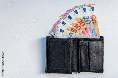 EURO-Geldscheine stecken in einem schwarzen Portemonnaie und stehen für Bargeld, Cash, Reichtum, passives Einkommen und Bezahlung im Finanzsektor photo