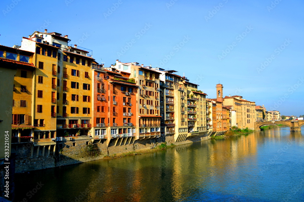View from a Bridge Overlooking the River in the Middle of Florence Italy With Colored Houses with Balconies on the Water's Edge