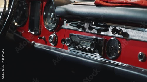 Close-up of dashboard panel of red retro car. Classic vintage car