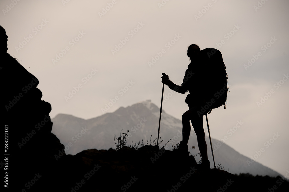 Silhouette girl standing on the rock with hiking backpack and walking ...