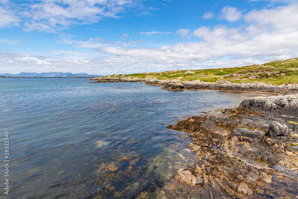 Beach with rocks and mountains in Carraroe