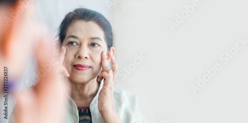 Foto Senior Adult Women show her crow's feet on the mirror