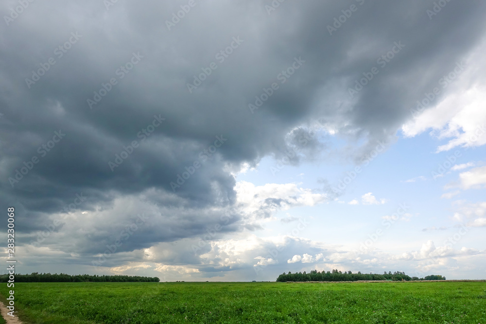 Dramatic countryside landscape with thunderclouds in the sky over a wheat field. Dramatic countryside landscape with thunderclouds in the sky over a wheat field.
