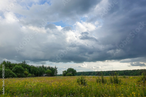 Landscape with thunderclouds over a green field. Russia Moscow region