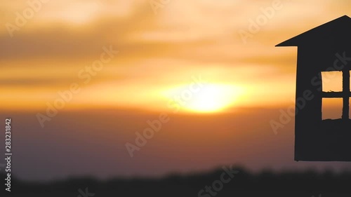 Hands of men and women holding a model of the house and the keys against the sunset. Silhouette of a paper house. photo