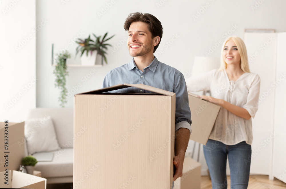 Happy Man And Woman Carrying Moving Boxes Into New Home Happy Man And Woman Carrying Moving Boxes Into New Home