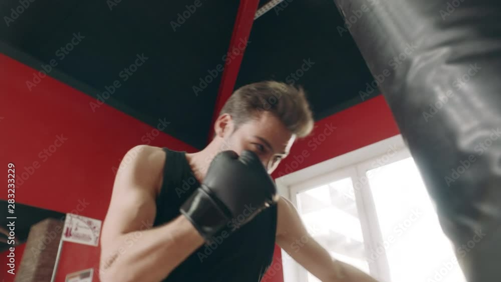 Kickboxer man making strikes at fight training. Sportsman having cardio training Kickboxer man making strikes at fight training. Sportsman having cardio training