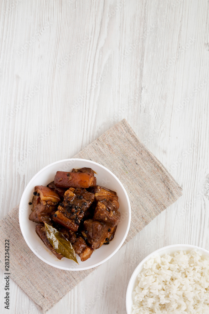Homemade Filipino Adobo Pork with rice on a white wooden table, top view. Flat lay, overhead, from above. Space for text. Homemade Filipino Adobo Pork with rice on a white wooden table, top view. Flat lay, overhead, from above. Space for text.