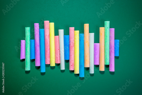 Multicolored chalks on a green chalkboard