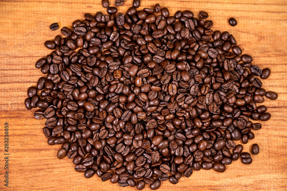 A coffee beans over wooden table top background. A coffee beans over wooden table top background.