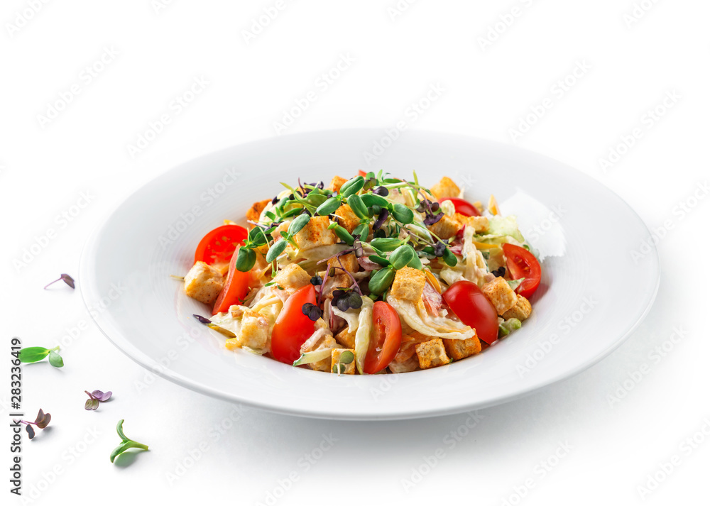 Caesar salad with lettuce, tomatoes, sprouts, croutons and sauce in plate on isolated white background. Healthy food, vegetarian dieting Caesar salad with lettuce, tomatoes, sprouts, croutons and sauce in plate on isolated white background. Healthy food, vegetarian dieting