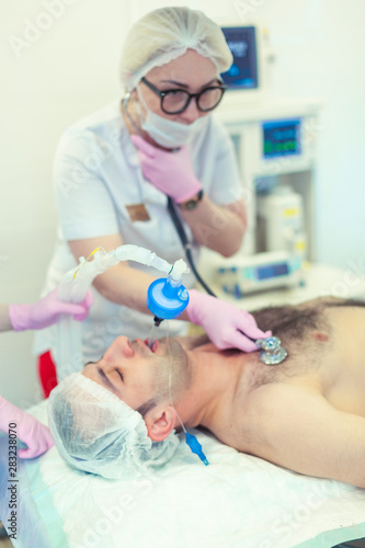 Anesthesiologist performing tracheal intubation in operation room. Preparation for surgery. Rhinoplasty