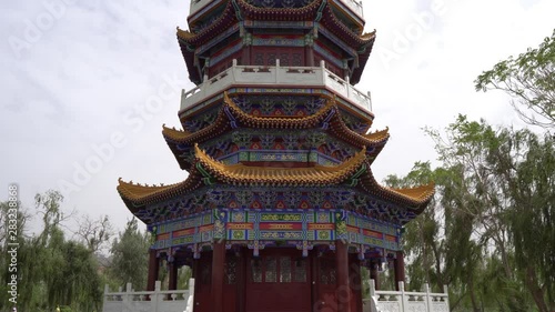  Hotan Picturesque Kunlun Lake Park Low Angle Frontal View of Pagoda with Cloudy Blue Sky at Background photo