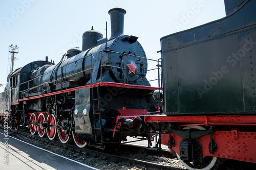 Black Soviet locomotive with a red star is on the rails.