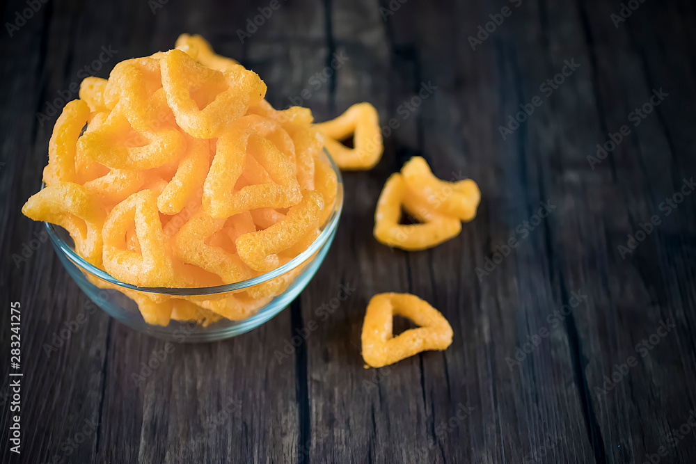 Crispy cornmeal snacks with cheese flavor in a brown bowl. Crispy cornmeal snacks with cheese flavor in a brown bowl.
