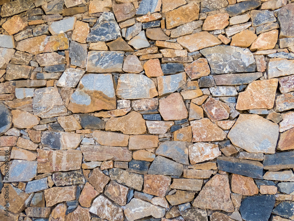 Fototapeta premium Old wall made of big and small stones . Vintage rough blocks surface background