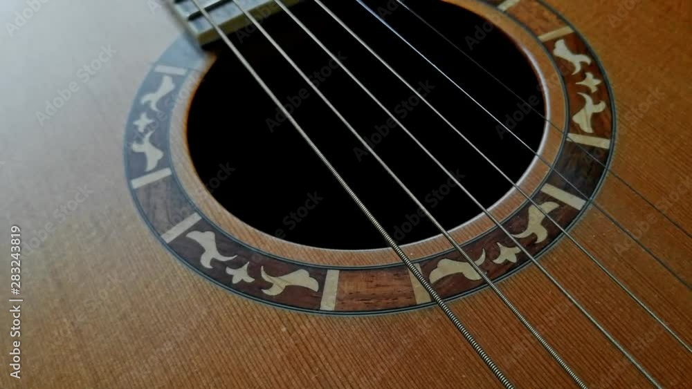 Close-up shot of a bridge, soundboard and strings in acoustic guitar. Close-up shot of a bridge, soundboard and strings in acoustic guitar.