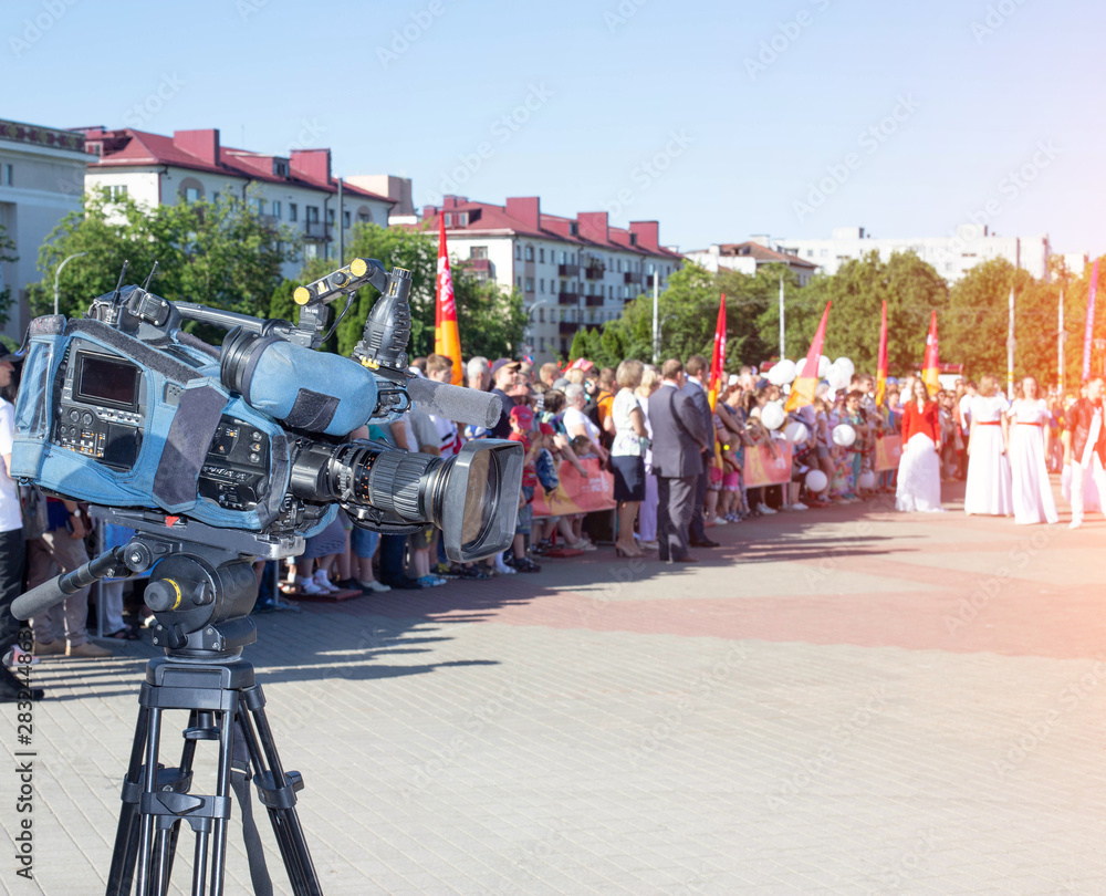 Camera against the background of a crowd of people in the city, journalism and news concept, copy space, holiday
