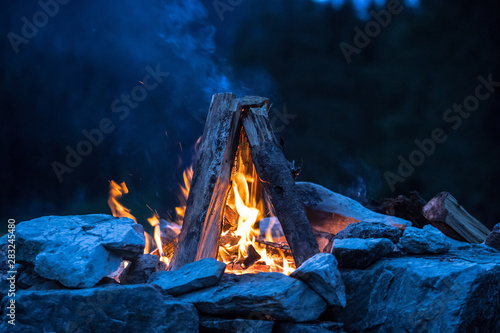 Camping bonfire with yellow and red flames in summer, forest. Copy space. photo