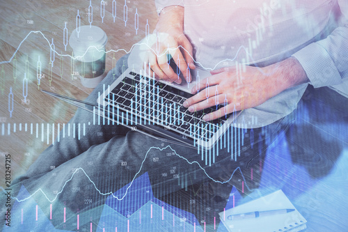 Forex graph with businessman working on computer in office on background. Concept of analysis. Double exposure.