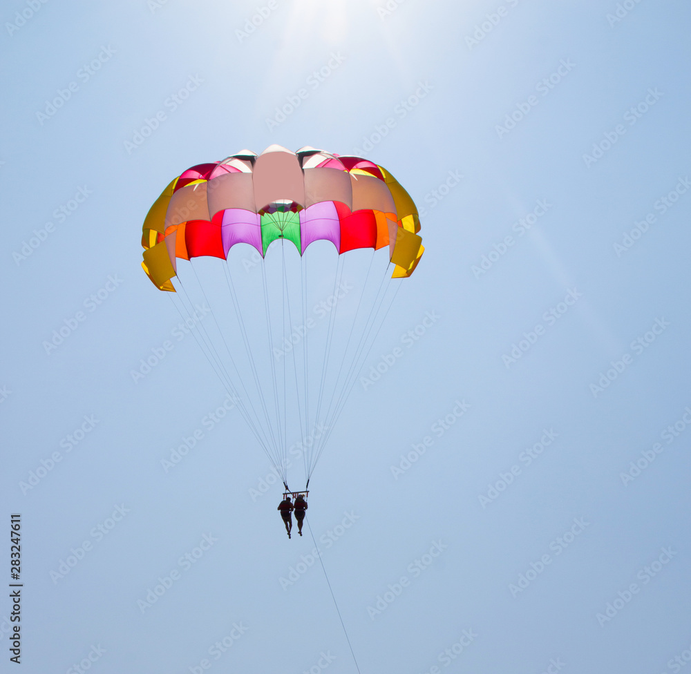 A couple in love fly across the sky on a parachute behind a yacht. A family that loves risky entertainment. Sea holidays in southern countries A couple in love fly across the sky on a parachute behind a yacht. A family that loves risky entertainment. Sea holidays in southern countries