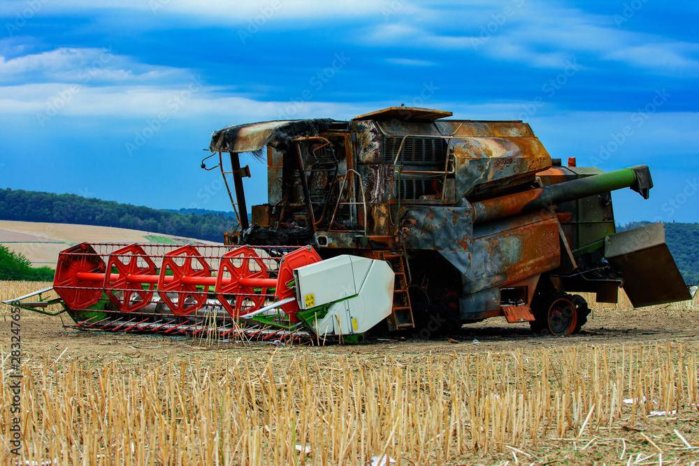 Fototapeta premium Ausgebrannter Mähdrescher auf einem Feld