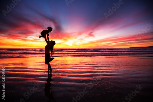 mother and son having fun at sunset on the beach