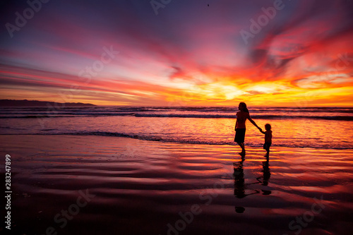 mother and son having fun at sunset on the beach