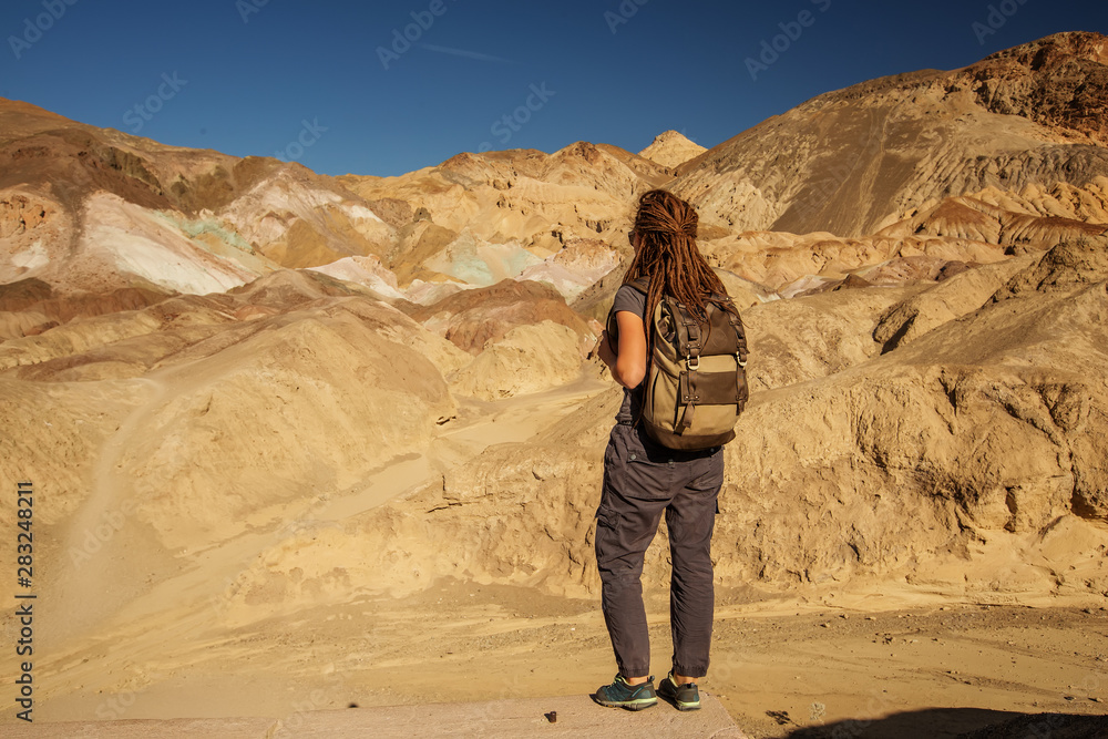 A hiker in the Artist`s Palette landmark place in Death Valley National Park, Geology, sand.