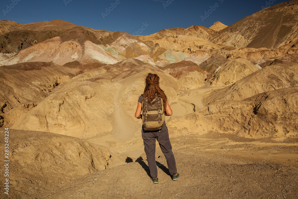 A hiker in the Artist`s Palette landmark place in Death Valley National Park, Geology, sand.