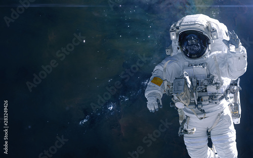 Astronaut on background of cosmic landscape. Nebulae and star clusters of deep space. Science fiction. Elements of this image furnished by NASA