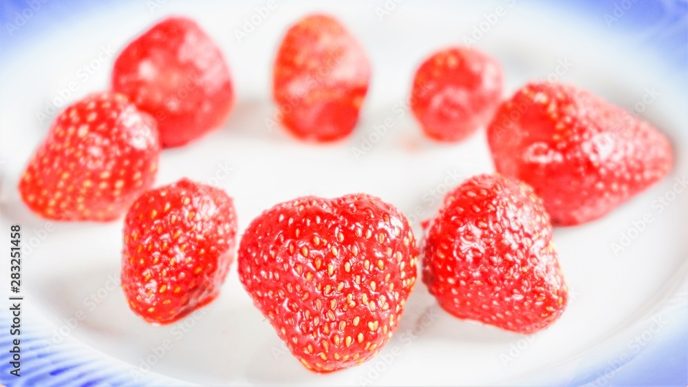 strawberry on a white plate with a blue border strawberry on a white plate with a blue border
