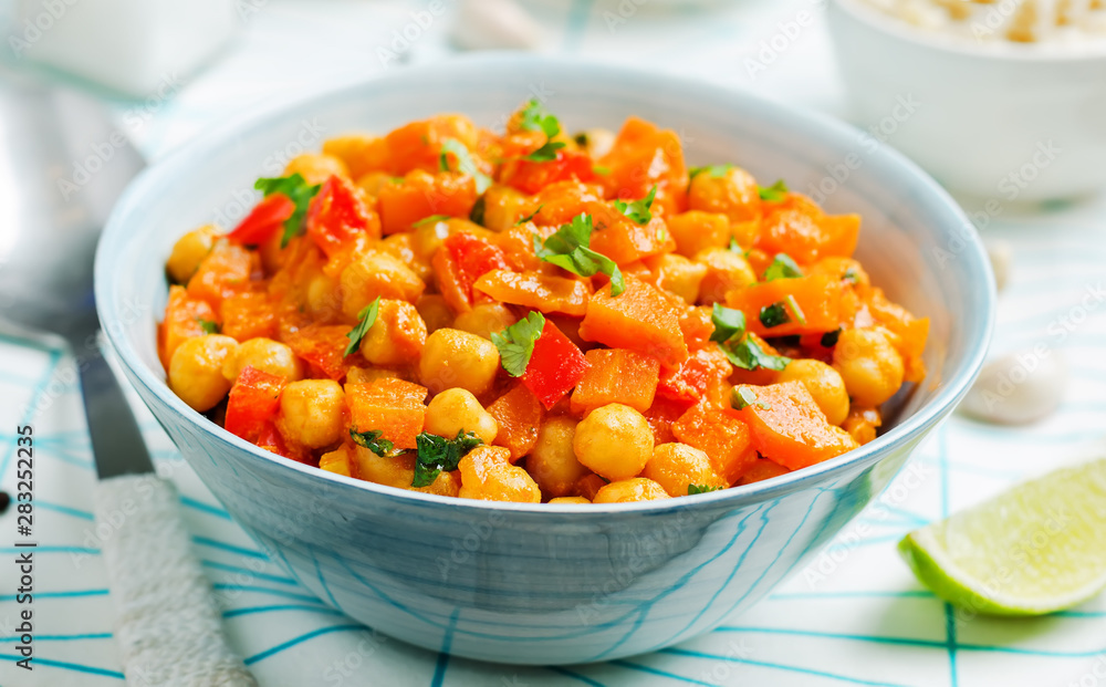 chickpeas carrots pepper coconut milk curry with brown rice on a wood background chickpeas carrots pepper coconut milk curry with brown rice on a wood background