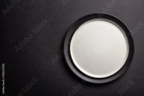 Elegant black table setting  plates  napkin and silverware over black background. Flat lay. copy space
