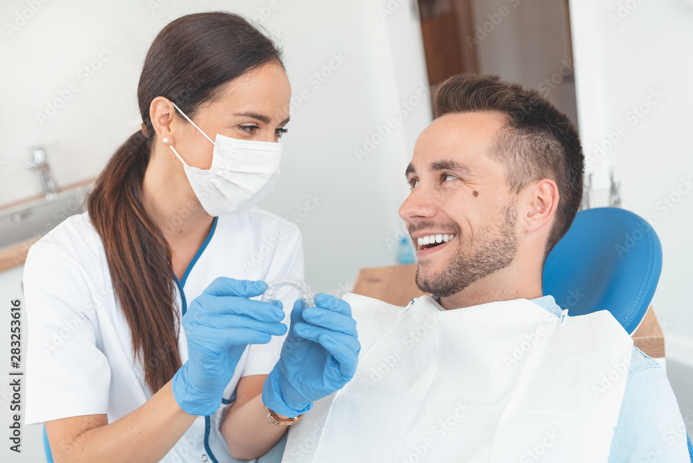 Dentist shows invisible braces aligner Dentist shows invisible braces aligner