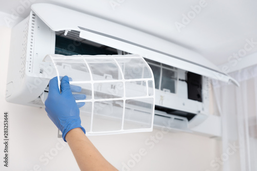 Canvas Print Technician cleaning air conditioner filter