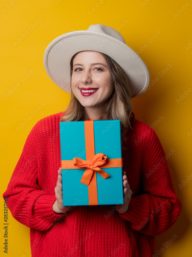 Young smiling woman in red sweater with gift box Young smiling woman in red sweater with gift box