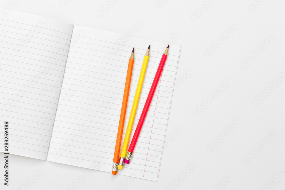 Blank notebook and pencils on white background. School supplies. White sketch book with colourful pencils. Note book and pencil Blank notebook and pencils on white background. School supplies. White sketch book with colourful pencils. Note book and pencil