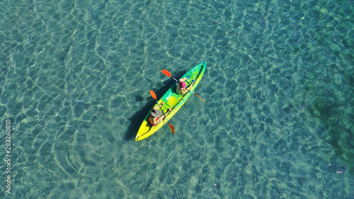 Aerial drone photo of 2 women canoeing in tropical Caribbean turquoise sea