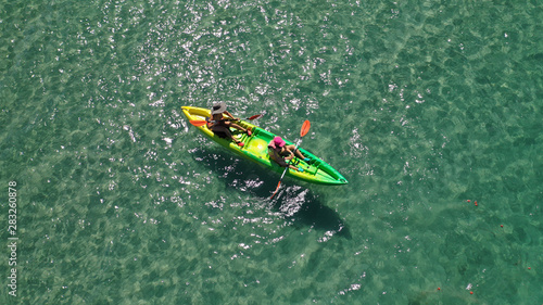 Aerial drone photo of 2 women practising canoe in open ocean tropical exotic sea