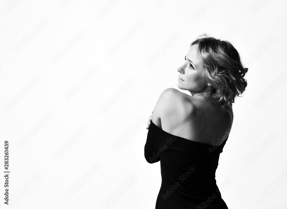 Fototapeta premium Beautiful woman actress with curly hair happy face emotions in black dress posing smiling. Black and white 