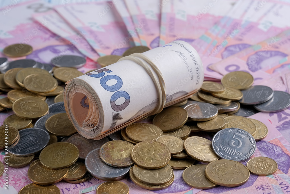 Ukrainian banknotes value of 200 and 500 hryvnia UAH and pile of coins. Ukrainian banknotes value of 200 and 500 hryvnia UAH and pile of coins.