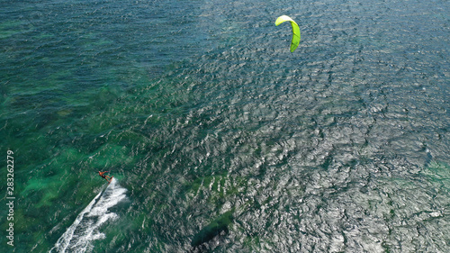 Aerial drone photo of kite surfer practising acrobatics in tropical exotic open ocean bay with emerald sea on a windy day