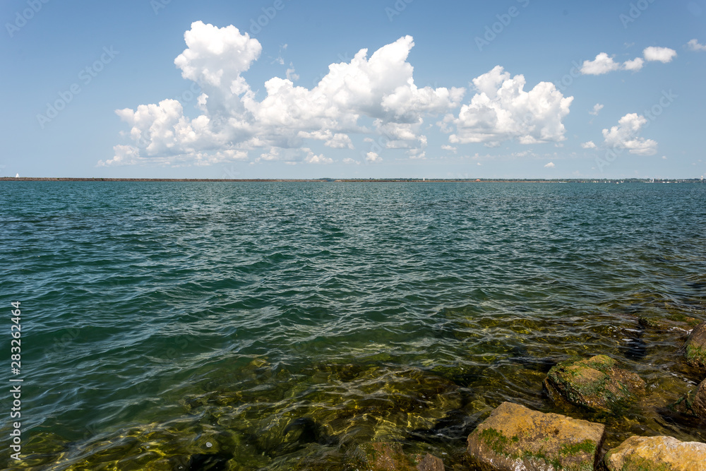 Large rocks rising from the clear blue lake water on a beautiful day Large rocks rising from the clear blue lake water on a beautiful day